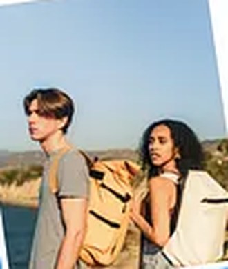 Two hikers with backpacks overlooking the coast